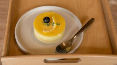 Nane yaprağı garnitürlü limonlu cheesecake, ahşap tepside servis edilir.