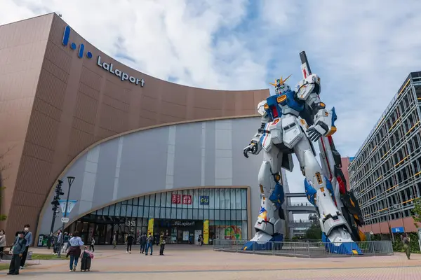 stock image traveller people visit Gundam life size RX 93ff  robot statue against blue sky at Mitsui Shopping Park LaLaport. Famous travel destination in city.