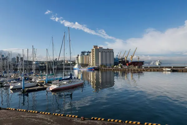 stock image Yacht and cargo boats by factory building with reflection on sea against blue sky, Shizuoka, Japan. View from Shimizu port. Logistic transportation and