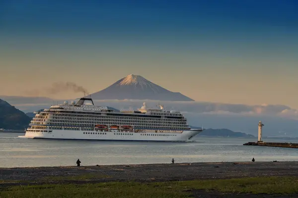 stock image Luxury tourist cruise sailing through Shimizu bay lighthouse and mount Fuji around Miho beach at dusk, Shizuoka, Japan. Transportation and travel destination industry.