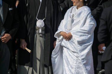 Smiling Japanese couple in traditional bride kimono and groom yukata uniform. Group photo after finishing tradition Japan wedding in Tsurugaoka Hachimangu Shrine at Kamakura. clipart