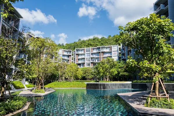 Khao Yai, Korat ya da Nakhon Ratchasima, Tayland 'da mavi gökyüzüne karşı modern apartman ya da otel binasıyla yüzme havuzu. Lüks tatilci ya da Siyam 'da tatil