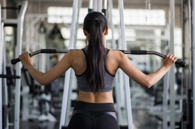Formda Asyalı kaslı genç kadın spor salonunda pompalayarak egzersiz yapıyor. Orta yaşlı kadınlar için vücut geliştirme ve sağlıklı yaşam tarzı.