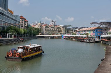 Singapur nehrinde yelkenliyle Clarke Quay ve Riverside Point 'i ziyaret eden turistler. Bölge, barları ve restoranları ile ünlüdür.