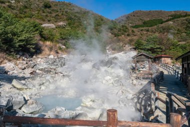 Cehennem Vadisi Jigoku, Unzen Dağı kaplıcalarında, Nagasaki, Kyushu, Japonya 'nın mavi gökyüzüne karşı. Sıcak su, gaz ve buhar jeotermal ısıtılmış volkanik kaynak alanı tarafından fışkırtılır..