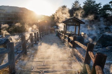 Unzen Cehennem Vadisi Jigoku Ryokan Oteli, Nagasaki, Kyushu, Japonya 'da gün batımında yoğun gaz buharı ile. Sıcak su, gaz ve buhar topraktan fışkırıyor.