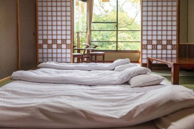 Geleneksel Japon tatami döşeme yatağı ve bahar bahçesi manzaralı balkonda rahat koltuk Yanagawa, Fukuoka, Japonya.