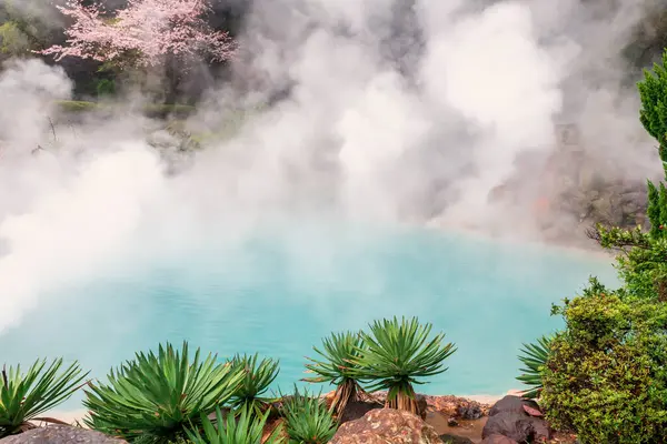 stock image Umi Jigoku Sea Hell or cobalt blue pond and white steam and pink cherry tree at Kamado Jigoku, Beppu, Oita, Japan. Travel destination and one of the most famous photogenic of the eight hells.