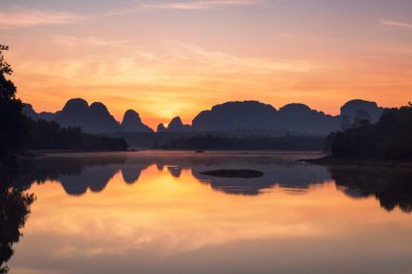 Nong Thale, Krabi, Tayland 'da şafak sökmeden önce ufuk çizgisi yansımalı bataklık ve kireçtaşı dağları. Ünlü seyahat beldesi ya da Tayland ya da Siyam 'da yaz tatilcisi.