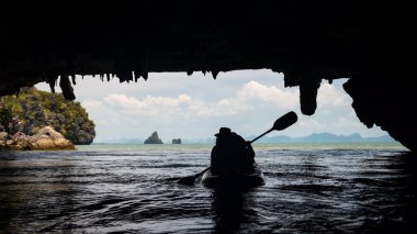 Tham Lod Yai Grotto Mağara Ormanı 'ndaki kano teknesindeki siluet turistleri Tayland' ın Phang Nga Körfezi 'ndeki kireçtaşı kayalıklarını kapladı. Ünlü tatil beldesi ya da tropikal ülke Siyam 'da tatilci.