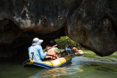 Turist ve denizci kanoyla Tham Lod 'dan ya da Tayland' ın Phang Nga Körfezi 'ndeki lagün ve mangrov ağacı bataklığını ziyaret etmek için Karst oluşumlarının mağarasından geçiyorlar. Yazın ünlü seyahat yeri