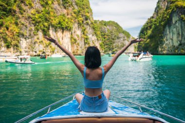 Tayland, Krabi 'deki Phi Phi Adası' ndaki Loh Samah Körfezi 'ndeki mutlu Asyalı kızın arkası. Ünlü tatil beldesi ya da tropikal ülke Siyam 'da yaz tatilcisi.