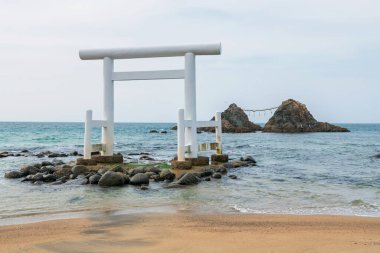 Beyaz torii kapısı ve Sakurai Futamigaura Itoshima, Fukuoka Bölgesi, Japonya 'da birkaç taş. Ünlü seyahat yeri ya da turistik yerler.