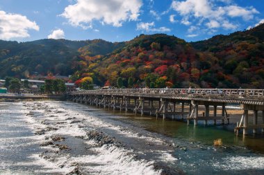 Arashiyama, Kyoto, Japonya 'da sonbahar yapraklı güzel Togetsukyo köprüsü. Özellikle sonbahar ve bahar mevsimlerinde Kansai 'de ünlü bir tatil beldesi..