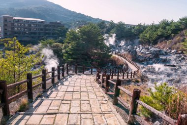 Nagasaki, Kyushu, Japonya 'daki Ryokan tatil beldesi yakınlarında Unzen Dağı' nın aşağısındaki Jigoku vadisinde. Sıcak kaynak suyu ve sülfür gazlarının ünlü varış yeri volkanik kaynak alanı..