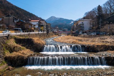 Shibu Onsen kaplıca kasabası ve Yokoyu nehri mavi gökyüzüne karşı, Nagano. Şehir kaplıcalarıyla ve Jigokudani maymun kar parkıyla ünlüdür..