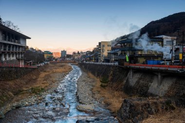 Shibu onsen kasabası, çağlayan su nehri ve Kiso Dağı 'nın merkezinde güneş doğarken, Nagano. Şehir kaplıcalarıyla ve Jigokudani maymun kar parkıyla ünlüdür..