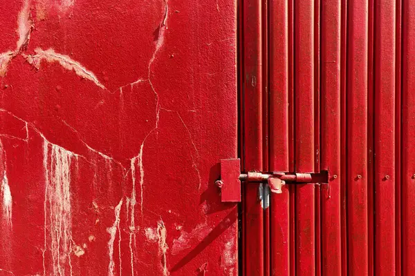 Paslı kırmızı metal çinko kapı ve grunge duvarında kilit var. Karakter ve güvenlik gösterisi. Eski dokulu arka plan kavramı.