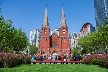 St. Ignatius Xujiahui Katedrali 'nin yanındaki bahçe meydanında Çin' in Şangay şehrinde mavi gökyüzüne karşı Çin halkı. Baharda Şangay Piskoposu 'nun yeri ve katedralin ünlü seyahat yeri..