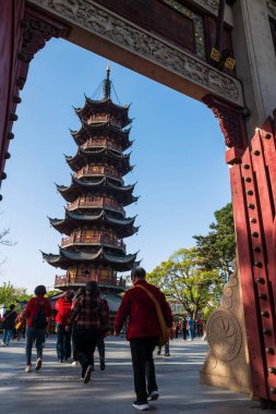 Çinliler Longhua tapınağının kapısından geçerek Şangay, Çin 'e giderler. Maitreya Buddha 'nın ünlü Budist tapınağı, Song hanedanlığının mimari tasarımı..