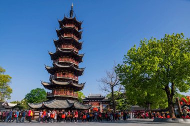 Şangay, Çin - 13 Nisan 2025: Çinliler Longhua tapınağının etrafında uçaksavar ateşi kulesi olarak yürüyorlar. Maitreya Buddha 'nın ünlü Budist tapınağı, Song hanedanlığının mimari tasarımı..