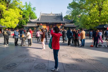 Çinli kadın kutsal Buda heykelini tütsü ya da tütsü çubuğuyla Longhua tapınağında kutsadı. Maitreya Buddha 'nın ünlü Budist tapınağı, Song hanedanlığının mimari tasarımı.