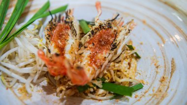 Pad Thai üzerine büyük karidesler ya da yumurtalı Tayland usulü kızarmış erişte. Restoranda ünlü Tayland yemekleri.