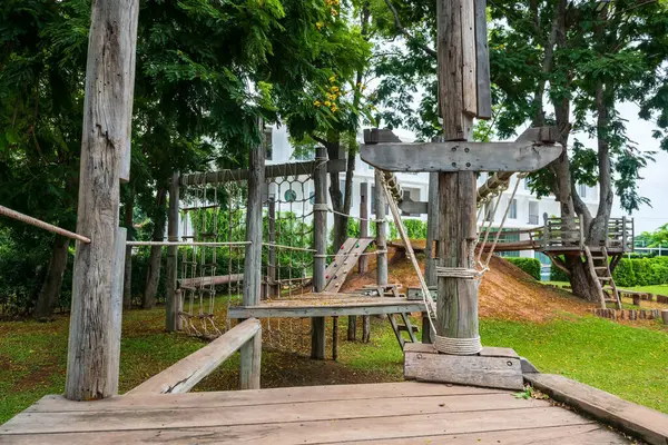 Kafe ve restoran bahçesinde yeşil çevresi olan ahşap çocuk oyun parkı.
