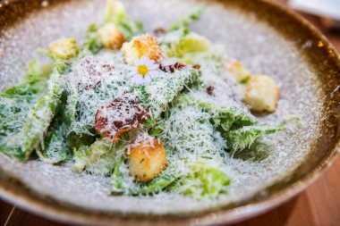 Gevrek pastırmalı sezar salatası ve restoranda tabakta ekmek. Yiyecek endüstrisi ve sağlıklı beslenme tarzı..