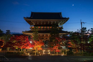 Konkai Komyo-ji Tapınağı 'nın Niomon dağ kapısı. Renkli akçaağaç yaprağı ışığı sonbaharda alacakaranlıkta, Kyoto, Japonya' da parlıyor. Sonbahar illüzyonu için Kansai 'yi gezmek için ünlü bir tatil beldesi..