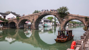 Tekne gezisindeki turistler Zhujiajiao 'daki Fangsheng Köprüsü' nü ziyaret ediyorlar. Qingpu Bölgesi 'ndeki antik su kasabası. Çin 'in Venedik' i olarak bilinen ünlü seyahat yeri.