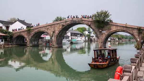 Tekne gezisindeki turistler Zhujiajiao 'daki Fangsheng Köprüsü' nü ziyaret ediyorlar. Qingpu Bölgesi 'ndeki antik su kasabası. Çin 'in Venedik' i olarak bilinen ünlü seyahat yeri.