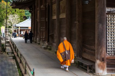Budist keşiş sonbaharda Hasedera tapınağının yanından geçer, Sakurai, Nara, Japonya. Aralık ayında Kansai 'de turistler için ünlü bir tatil beldesi..