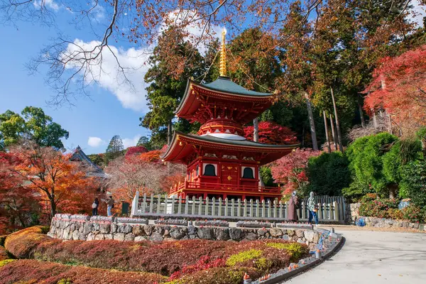 İnsanlar sonbahar bahçesinde mavi gökyüzü, Minoh, Osaka, Japonya 'ya karşı renkli akçaağaç yaprağıyla Katsuo-ji tapınağını ziyaret ediyor. Sonbaharda Kansai 'yi görmek için seyahat yeri. Zafer tapınağı