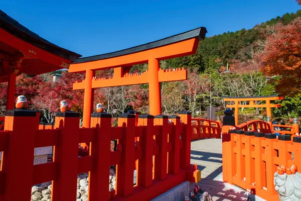 Daruma bebekleri sonbaharda Japonya 'nın Minoh, Osaka kentinde Katsuo-ji tapınağının kırmızı tapınak duvarında ve torii kapısında. Sonbahar mevsiminde Kansai 'yi gezmek için ünlü bir gezi yeri. Zafer tapınağı.