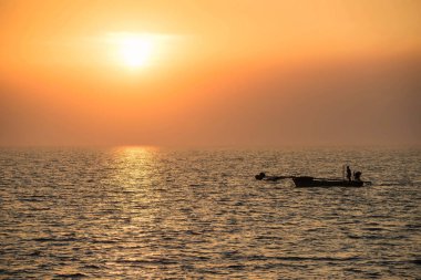 Siluet balıkçısı gün batımında denize yelken açıp balık tutmaya gidiyor. Bang Pu, Samut Prakan, Tayland. Martı görmek için ünlü bir seyahat yeri. Deniz ürünleri endüstrisi için balık avlama.