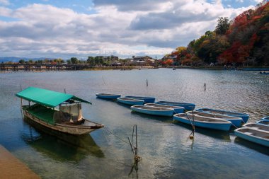 Katsura nehri üzerinde Togetsukyo köprüsünün yanında Aralık ayında Arashiyama, Kyoto, Japonya 'da sonbahar yeşillik renkleriyle. Sonbahar mevsiminde Kansai 'de ünlü bir seyahat merkezi..