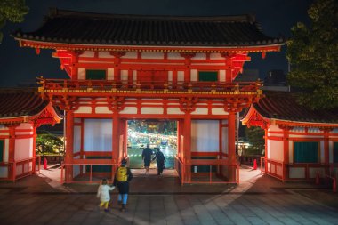 İnsanlar Yasaka tapınağının ana kapısı Ro-mon 'dan gece Gion bölgesi manzarasıyla geçiyorlar. Yerel işletmeler tapınağa bağışta bulundular ve her fenerin üzerine isimleri yazıldı..