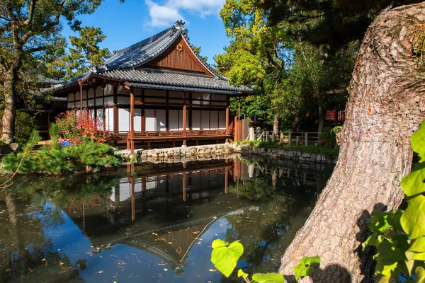 Sumiyoshi Taisha Saikan sonbaharda Japonya 'nın Osaka kentinde mavi gökyüzüne karşı gölete yansıdı. Sonbahar mevsiminde Kansai 'yi gezmek için ünlü bir tatil beldesi..