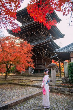 Beyaz kimonolu Japon bayan Shinnyodo pagoda ve kırmızı sonbahar akçaağaç yaprağı, Kyoto, Japonya manzaralı. Sonbahar mevsiminde Kansai 'yi gezmek için ünlü bir tatil beldesi..