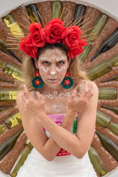 stock image Portrait of mexican woman in traditional make up and bride Catrina costume posing at a wall with a circle made from wine bottles and mosaic pieces