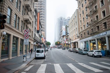 SAN FRANCISCO, CALIFORNIA, USA- 10 AĞUSTOS 2023: San Francisco, Kaliforniya, ABD 'de bulutlu bir günde arabalı ve tipik binalı bir cadde manzarası