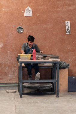 SAN MARTIN TILCAJETE, OAXACA, MEXICO-JANUARY 19, 2023: San Martin Tilcajete, Oaxaca, Meksika 'da kil kase yapan genç Meksikalı adam