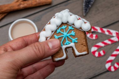 Zencefilli kurabiye evi tutan bir kadın. Ahşap arka plan. Noel