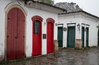 PARATY, RIO DE JANEIRO, BRAZIL- 30 Temmuz 2024: Paraty, Rio de Janeiro, Brezilya 'da sokak manzaralı yağmurlu bir günde Portekiz tarzı koloni evleri ve mağazaları