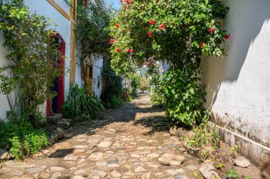 PARATY, RIO DE JANEIRO, BRAZIL- 31 Temmuz 2024: Paraty, Rio de Janeiro, Brezilya 'da güneşli bir günde Portekiz tarzı koloni evleri ve mağazaları ile sokak manzarası