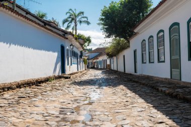 PARATY, RIO DE JANEIRO, BRAZIL- 31 Temmuz 2024: Paraty, Rio de Janeiro, Brezilya 'da güneşli bir günde Portekiz tarzı koloni evleri ve mağazaları ile sokak manzarası