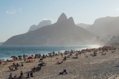 RIO DE JANEIRO, BRAZIL- 2 AĞUSTOS 2024: Brezilya 'nın Rio de Janeiro şehrinde gün batımında ünlü Sugar Loaf dağlı Ipanema plajı manzarası