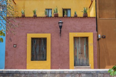 OAXACA, OAXACA, MEXICO - 4 Mayıs 2025: Oaxaca, Meksika 'da geleneksel kırmızı ve sarı bir ev cephesi