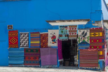 OAXACA, OAXACA, MEXICO - 4 Mayıs 2025: Oaxaca şehir merkezinde güneşli bir günde el yapımı halı satan renkli mavi mağaza